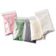 Five bags of different colored powders on a white background