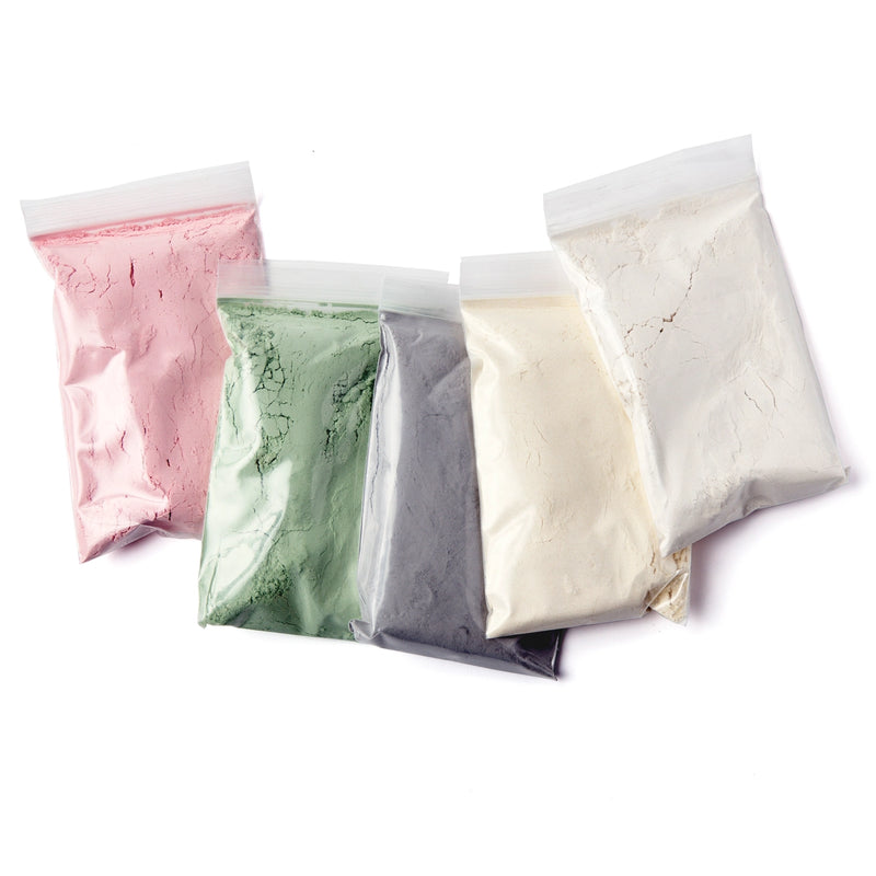 Five bags of different colored powders on a white background