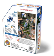 Jigsaw puzzle packaging with people interacting with a blue heron puzzle, featuring text and branding.