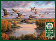 picture of box cover. Cloudy skies over a lake and autumnal trees featuring 14 geese migrating. 