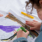 Child coloring a picture with the beeswax crayons on a coloring sheet 