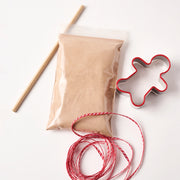 showing kit items, dough mix, ribbon, straw hole punch & gingerbread man shaped cookie cutter
