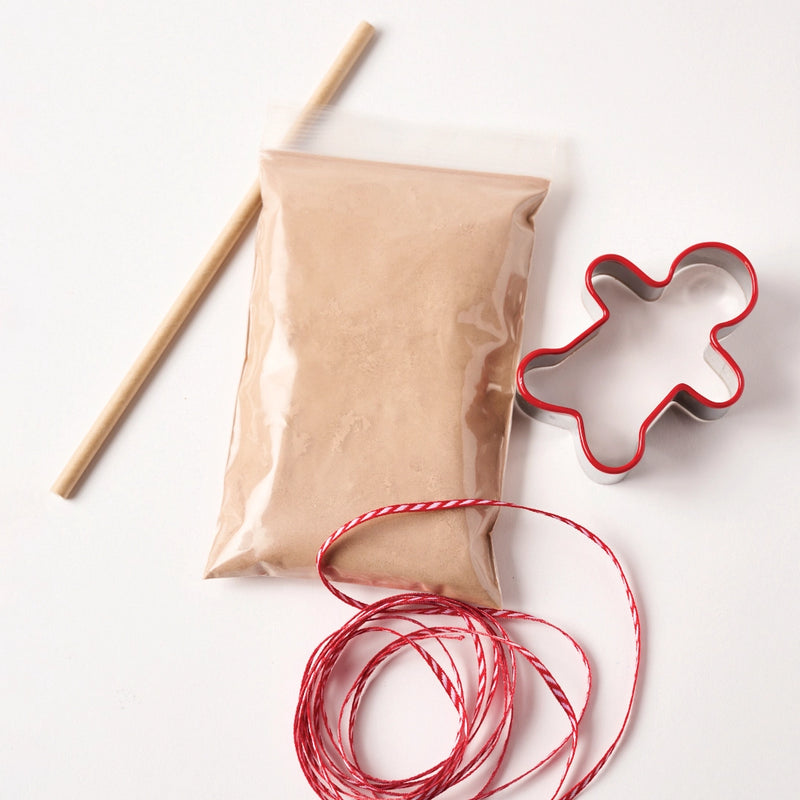showing kit items, dough mix, ribbon, straw hole punch & gingerbread man shaped cookie cutter