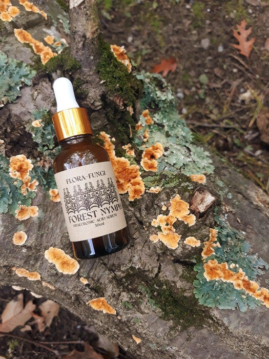 Forest Nymph Hyaluronic Acid Serum on log with lichen
