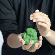 Person holding a green ball of eco dough 
