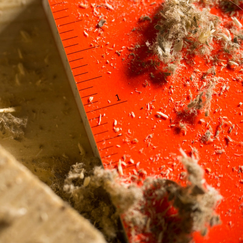 Close-up of a ruler in notebook covered in sawdust