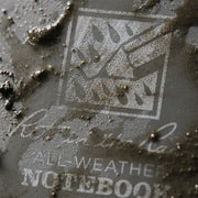 close up on grey notebook cover with mud on it