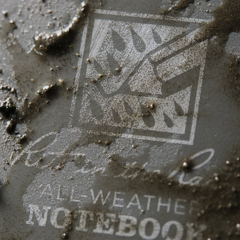 close up on grey notebook cover with mud on it