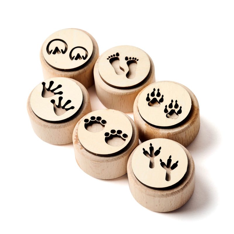 Set of wooden stamps with animal footprint designs on a white background