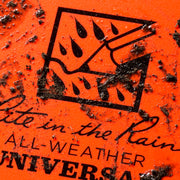 All-weather orange notebook cover with mud and dirt on it