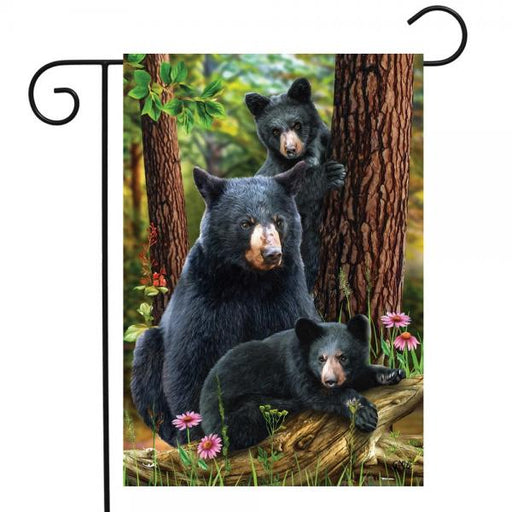 flag features a mother black bear and two cubs hanging out in the woods near a fallen log and trees