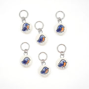 Set of six bluebird-themed ceramic stitch markers on a white background