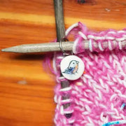 Ceramic stitch marker with pink yarn knitting sample on a size 10 knitting needle  