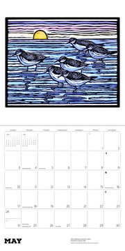 Calendar page with a stylized illustration of birds on a beach at sunset.