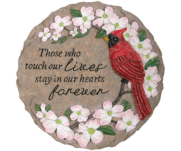 round, tan stepping stone with text that reads "those who touch our lives stay in our hearts forever" featuring a cardinal perched in a blossoming branch. 