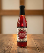 Bottle of cranberry shrub with a black cap 