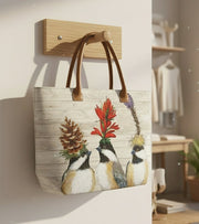Tote bag with faux leather handles featuring three chickadees wearing floral hats on a wooden background in a boutique setting