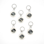 Set of six chickadee-themed ceramic stitch markers on a white background