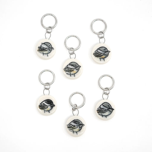 Set of six chickadee-themed ceramic stitch markers on a white background