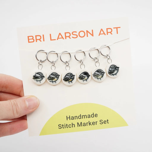 Handmade ceramic stitch marker set with chickadee design on a Bri Larson Art branded card.
