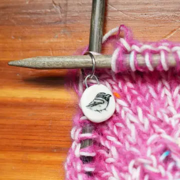 Ceramic stitch marker with pink yarn knitting sample on a size 10 knitting needle