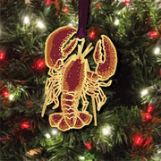 Decorative lobster ornament on a holiday tree with lights.