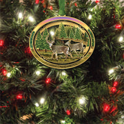 Decorative ornament with deer design on a lit Christmas tree.