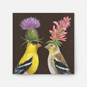 Two goldfinches with floral hats on a dark background