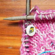 Ceramic stitch marker with pink yarn knitting sample on a size 10 knitting needle
