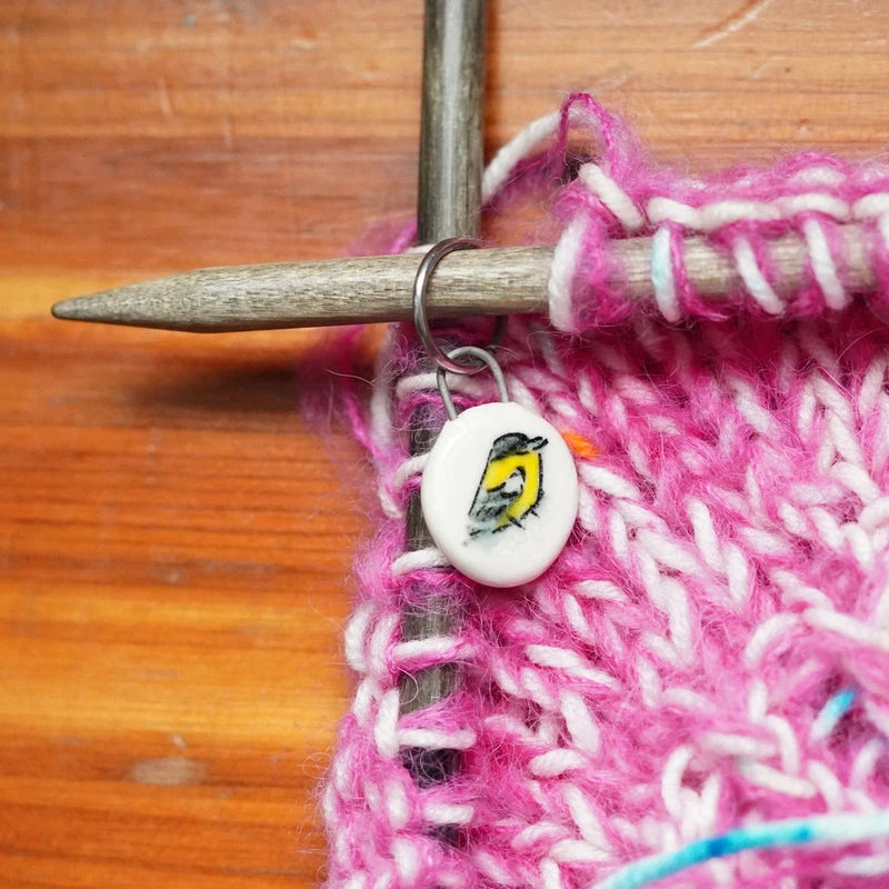 Ceramic stitch marker with pink yarn knitting sample on a size 10 knitting needle