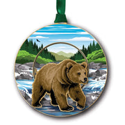 Circular ornament with a grizzly bear design featuring a forest and mountain landscape.