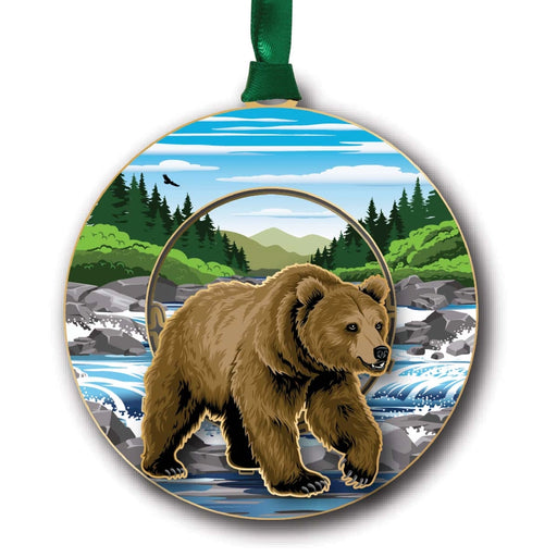Circular ornament with a grizzly bear design featuring a forest and mountain landscape.