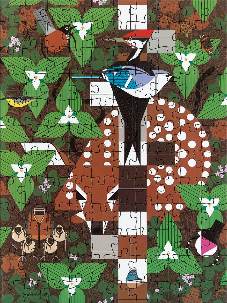 Jigsaw puzzle with a wildlife design featuring a fawn, wild birds, and trillium flowers 