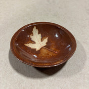 Brown ceramic bowl with a maple leaf design