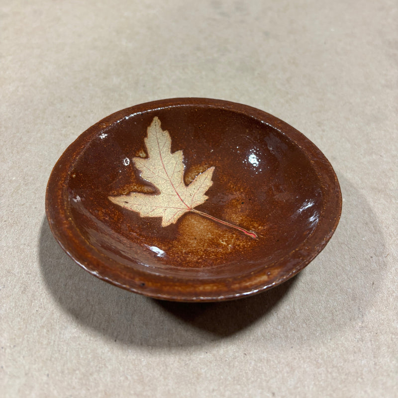 Brown ceramic bowl with a maple leaf design