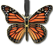 Butterfly-shaped ornament with orange and black wings on a white background