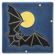 Decorative tile with black bat design against a deep blue background with a full yellow moon.