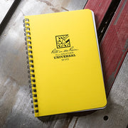 Yellow notebook with 'Rite in the Rain' branding on a wooden surface