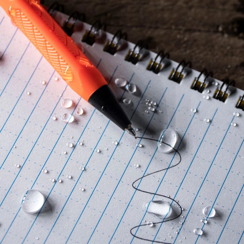 Orange pen on lined paper with water droplets