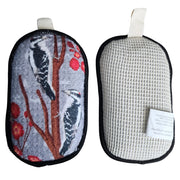 Two pouches sides of reversible reusable sponge, one with bird design and the other with cotton mesh textured surface, on a white background.