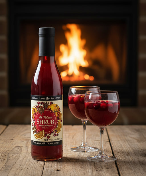 bottle and two classes full with cranberries floating. fireplace in background