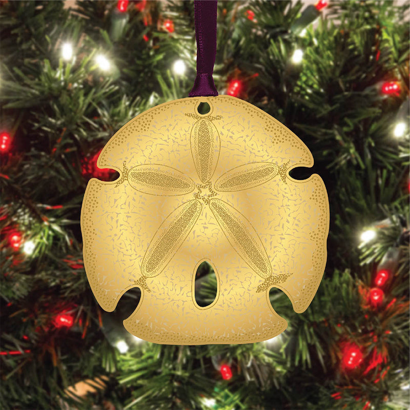 Gold sand dollar ornament on a Christmas tree with lights.