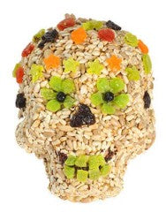 Skull-shaped treat with colorful decorations on a white background - Green Eyes