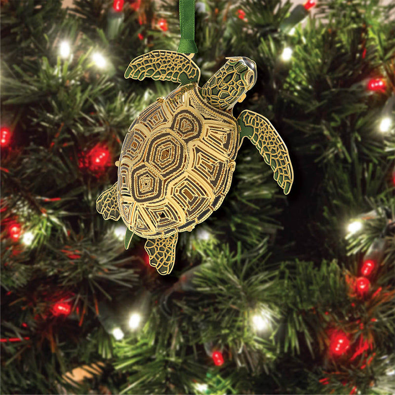 Sea turtle-shaped Christmas ornament on a decorated tree with lights.