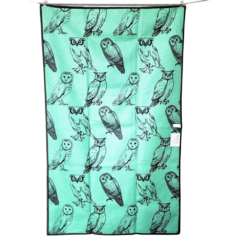 Teal towel with black owl pattern on a white background