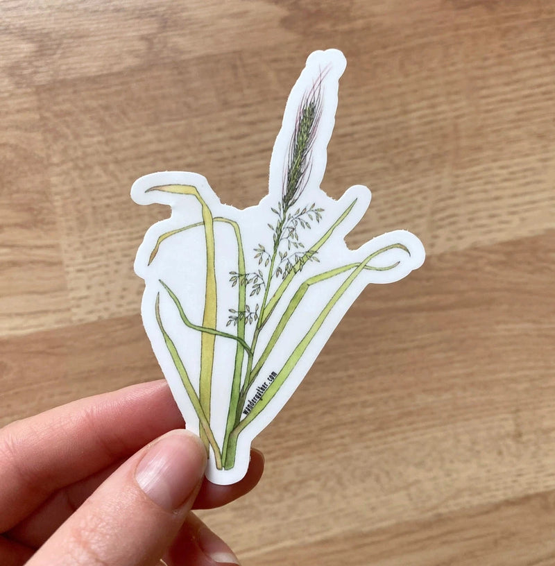 Hand holding a sticker of a wild rice Manoomin plant design