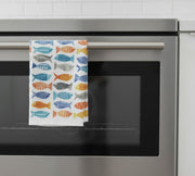 kitchen towel with fish prints hanging off an oven door