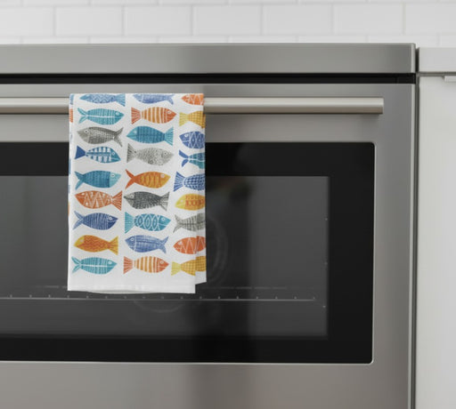 kitchen towel with fish prints hanging off an oven door