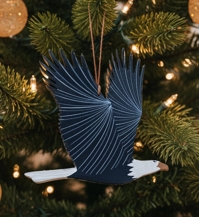 Decorative eagle ornament with open wings on a evergreen background