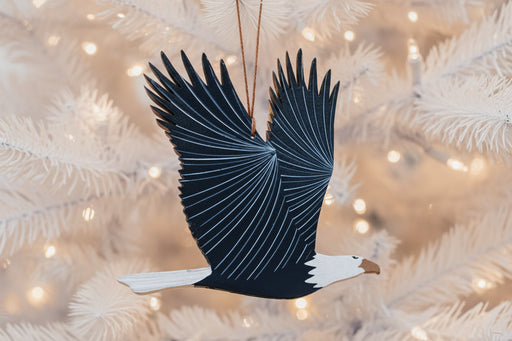 Decorative eagle ornament with open wings on a evergreen background